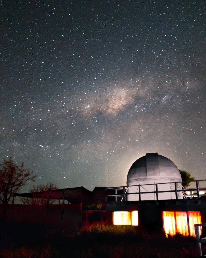 Photograph of a lit up building under a dark starry sky.